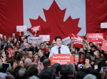 Egy óriási nemzeti lobogó előtt beszél Justin Trudeau, Kanada  újonnan megválasztott miniszterelnöke.